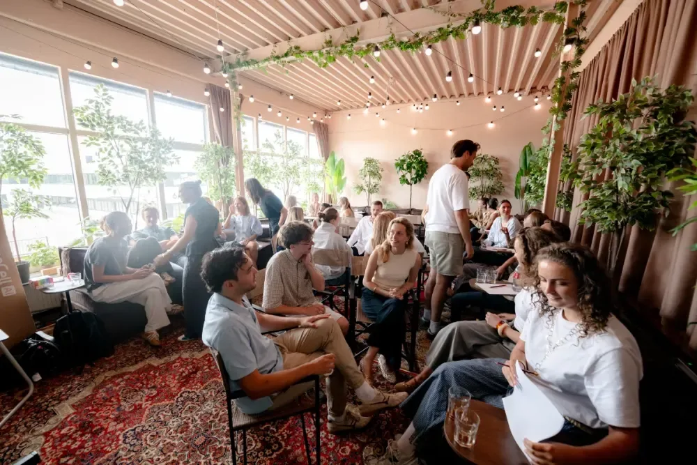 Workshopruimte in Utrecht tijdens een sessie, deelnemers in gesprek in groepjes